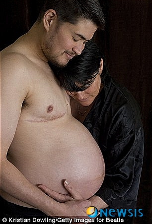 【서울=뉴시스】세계 최초로 '임신한 남성'으로 유명한 미국의 토머스 비티(37)가 지난 2008년 첫 딸 수잔을 임신했을 당시 자신의 만삭의 배를 부인 낸시와 바라보고 있다. (사진 출처 : 英 데일리 메일 웹사이트)
