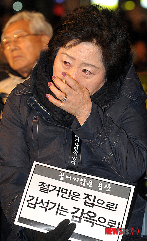 【서울=뉴시스】조종원 기자 = 19일 저녁 서울역 광장에서 열린 '용산참사 3주기 추모대회'에서 한 유가족이 눈물을 흘리고 있다.  choswat@newsis.com