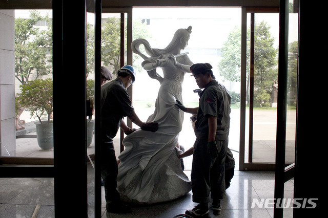 【AP/뉴시스】 북한 노동자들이 만수대창작사에서 조각상을 옮기고 있다. 2013.06.20