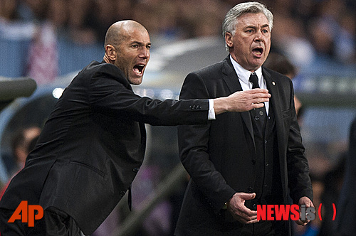 Real Madrid's assistant coach Zinedine Zidane from France, left, and coach Carlo Ancelotti from Italy, right, gesture during a Spanish La Liga soccer match at La Rosaleda stadium in Malaga, Spain, Saturday March 15, 2014. (AP Photo/Daniel Tejedor)