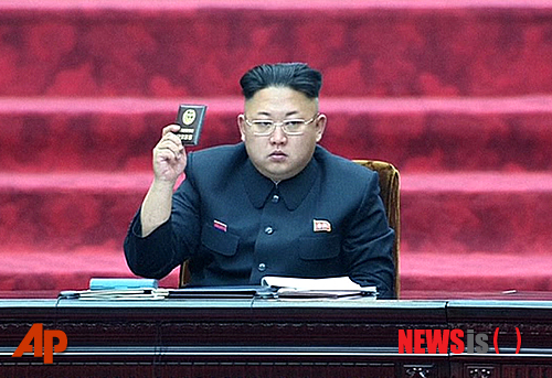 【평양=AP/뉴시스】지난 9일 북한에서 열린 제13기 1차 최고인민회의에서 김정은 제1국방위원장이 당원증을 들고 앉아 있는 모습. 2014.04.10
