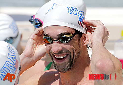 Michael Phelps warms up prior to competing in the 100-meter butterfly during the Arena Grand Prix swim meet, Thursday, April 24, 2014, in Mesa, Ariz. It is Phelps' first competitive event after a nearly two-year retirement. (AP Photo/Matt York) 