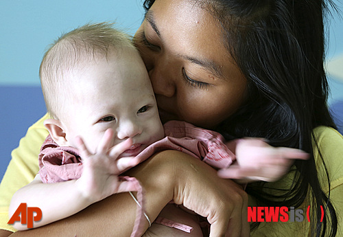 【촌부리=AP/뉴시스】2014년 8월 태국 동남부 촌부리의 한 병원에서 대리모 파타라몬 찬부아(21)가 가미에게 키스를 하고 있다. 태국 대리모에게서 태어난 가미라는 이름의 아기가 장애를 이유로 호주 부모로부터 버림을 받았다는 사연이 알려진 후 호주 당국이 진상 조사에 나섰다. 2014.08.04