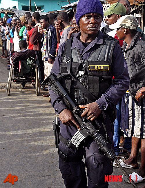  【몬로비아 =AP/뉴시스】라이베리아 정부가 에볼라 확산을 막기 위해 봉쇄한 수도 몬로비아의 슬럼가 웨스트포인트를 무장 보안군이 순찰하고 있다. 