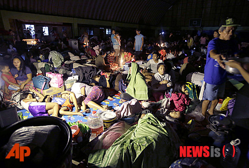 【마닐라=AP/뉴시스】제16호 태풍 풍웡으로 필리핀 곳곳이 물에 잠긴 가운데 주민이 19일(현지시간) 마닐라 동시 마리키나에서 집중호우를 피해 대피소에 모여 있다. 필리핀 국가재난당국이 20일 태풍 피해로 마닐라와 인근 지역 주민 50만 명이 넘는 이재민이 발생했으며 최소 5명이 숨지고 9만명이 대피했다고 밝혔다. 2014.09.20 