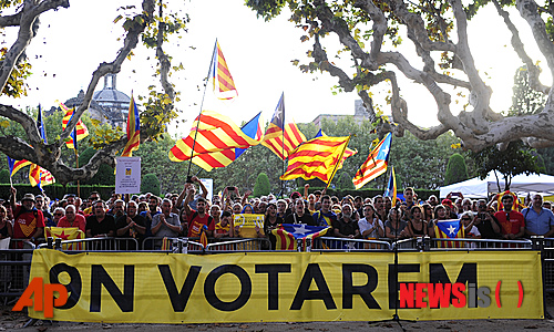 【바르셀로나=AP/뉴시스】스페인 카탈루냐 주민이 19일(현지시간) 바르셀로나에 있는 의사당 밖에서 카탈루냐 독립을 요구하는 시위 중 카탈루냐 독립을 상징하는 깃발을 흔들고 있다. 배너에는 ‘11월9일 주민투표 강행’이라고 쓰여 있다. 스코틀랜드의 분리·독립 주민투표가 부결되고 다음날 카탈루냐 주의가 주지사가 주민투표를 치르도록 권한을 부여하는 주민투표안을 통과시켰다. 스페인 중안 정부는 이 투표를 불법으로 규정할 것으로 예상된다. 2014.09.21