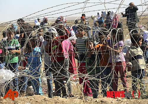 【수르크=AP/뉴시스】21일(현지시간) 터키 수르크 국경에서 수백명의 시리아 난민들이 국경 통과를 기다리고 있다. 터키가 20일 이슬람 무장세력을 피해 탈출한 6만 명의 난민을 수용하기 위해 국경을 임시로 개방했다. 2014.09.22 