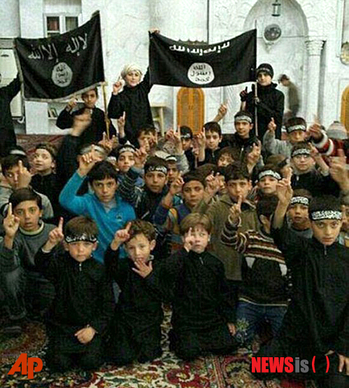 【라카=AP/뉴시스】시리아에서 이슬람 수니파 무장단체 이슬람국가(IS)과 싸우는 한 반군이 지난 20일(현지시간) 공개한 사진으로 시리아 어린이들이 라카에서 IS의 깃발을 들고 단체사진을 찍고 있다. 이는 최근 IS가 장악한 이라크와 시리아 지역 곳곳에서 어린이들에게 IS의 급진적이고 극렬한 이슬람 법 해석을 가르치고 있다는 AP통신의 보도와 일치하는 사진이다. 2014.11.25