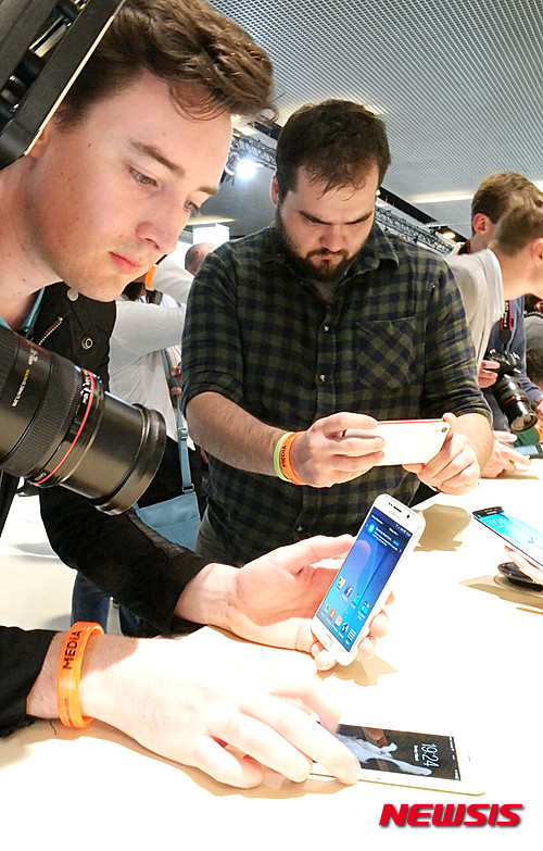 【서울=뉴시스】삼성전자가 1일(현지시간) 스페인 바르셀로나 컨벤션센터(CCIB)에서 '삼성 갤럭시 언팩 2015'를 개최하고, 전략 스마트폰 '갤럭시S6'와 '갤럭시 S6 엣지'를 공개한 가운데 언팩 행사를 찾은 관람객들이 제품을 살펴보고 있다. 2015.03.02. (사진=삼성전자 제공)  photo@newsis.com 