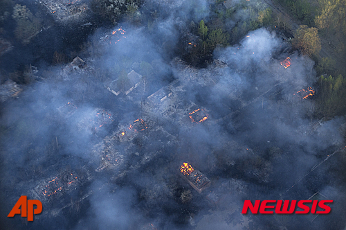 【체르노빌=AP/뉴시스】우크라이나 체르노빌 원전 출입금지 구역 지역에 28일(현지시간) 발생한 대형 산불로 버려진 마을이 불에 타고 있다. 아르세니 야체뉴크 우크라이나 총리는 이날 20년 만에 최악의 산불이 발생했지만, 불길이 잡히고 있다고 밝혔다. 2015.04.29