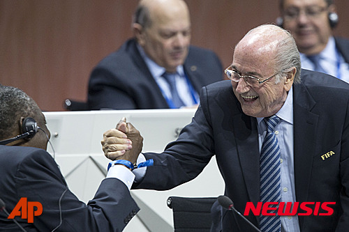 FIFA president Sepp Blatter, right, shakes hands with senior Vice President Issa Hayatou during the 65th FIFA Congress held at the Hallenstadion in Zurich, Switzerland, Friday, May 29, 2015, where Blatter runs for re-election as FIFA head. (Patrick B. Kraemer/Keystone via AP)