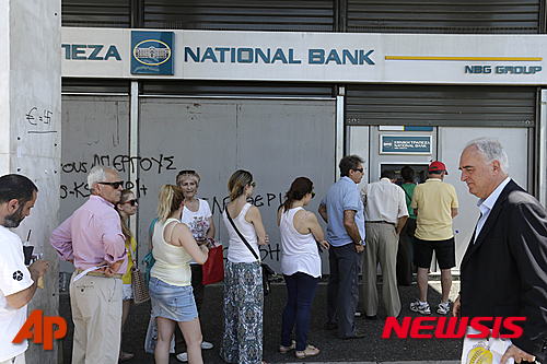 【아테네=AP/뉴시스】6일(현지시간) 그리스 아테네 시내의 한 은행 ATM(현금지급기) 앞에서 사람들이 줄을 서고 있다. 그리스 정부는 하루 인출 한도를 60유로로 제한하고 있다. 2015.07.07