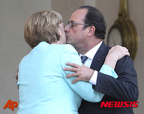 【파리 =AP/뉴시스】프랑수아 올랑드 프랑스 대통령(오른쪽)이 6일 파리 엘리제 궁에서 앙겔라 메르켈 독일 총리에게 키스를 하고 있다. 메르켈은 그리스 구제금융 문제를 협의하기 위해 엘리제궁을 방문했다. 2015.7.7 