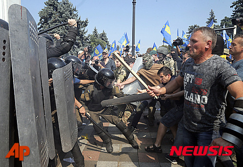 【키에프=AP/뉴시스】31일 우크라이나 의회가 동부 지역의 자치권을 확대하는 헌법 수정안을 1차 투표에서 가결시킨 후 성난 시위대가 의회로 몰려오자 경찰이 막고 있다. 동부 지역의 친 러시아 분리주의자들은 정부군과 전쟁을 불사하며 러시아 편입을 시도하고 있다. 1차 투표에서는 265명이 찬성했으나 1일 2차 투표는 300명의 찬성이 필요하다. 2015. 8. 31.