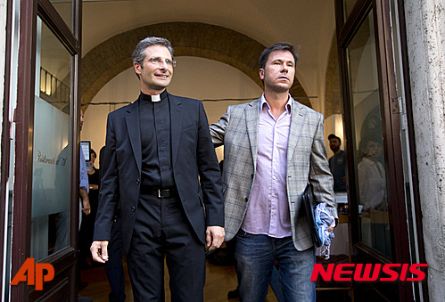 【 로마=AP/뉴시스】교황청 신앙교리성에서 활동하는 크리스토프 카람사 신부(왼쪽)가 3일(현지시간) 이탈리아로마에서 동성애인 에두아르드(오른쪽)와 함께 기자회견을 열어 동성애자임을 밝힌 후 나란히 회견장을 걸어나오고 잇다. 2015.10.04