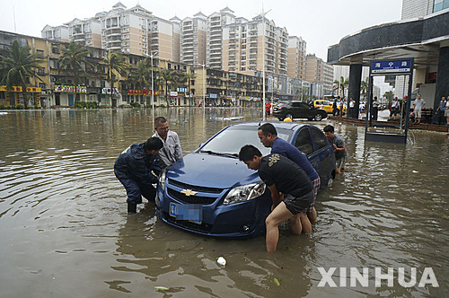 【 잔장 = 신화/뉴시스】 중국 광둥성 잔장에서 4일 태풍 무지개의 영향으로 폭우가 내리면서 홍수가 발생해 주민들이 물에 잠긴 자동차를 옮기려 애쓰고 있다. 2015.10.05