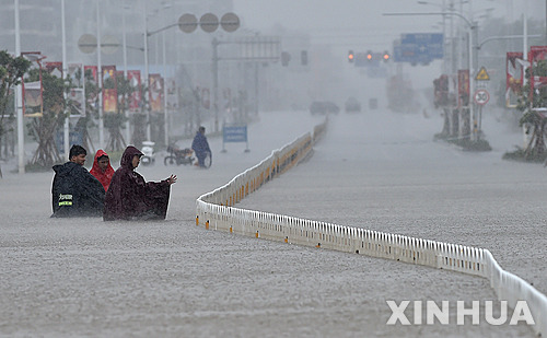【하이쿠= 신화/뉴시스】태풍 무지개가 강타한 4일 중국 하이난성 하이쿠에서 홍수가 발생해 주민들이 물을 헤치고 걸어가고 있다. 2015.10.05 