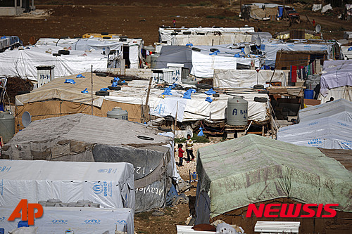 【베카밸리(레바논)=AP/뉴시스】 2015년 10월 레바논 동부 베카밸리에 위치한 난민촌에서 시리아 난민들이 텐트 밖에 서있다. 2015.10.29