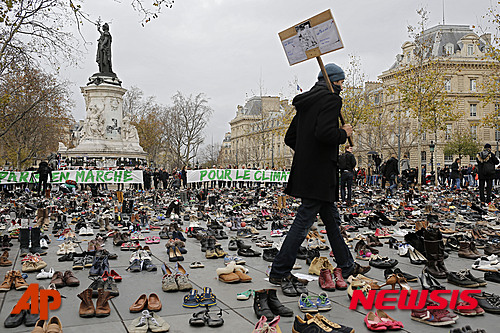 【파리=AP/뉴시스】제21차 유엔기후변화협약 당사국총회(COP21) 개막을 하루 앞둔 29일(현지시간) 프랑스 파리 레퓌블리크 광장에서 남성이 시위 대신 항의 차원으로 일렬로 정렬된 수백 켤레의 신발 사이를 걸어가고 있다. 2015.11.30 
