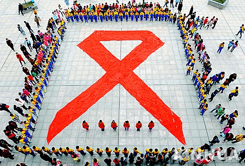 【더싱=AP/뉴시스】중국 장시성 더싱에서 1일 학생들이 세계 에이즈의 날을 맞아 붉은 스카프로 대형 에이즈 상징 리본을 만든 후 주변에 서있다. 2015.12.01