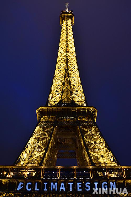 【파리=신화/뉴시스】2015년 12월 12일(현지시간) 프랑스 파리에서 열린 유엔 기후변화협약 당사국총회에서 지구온난화에 대응하기 위해 전 세계가 참여하는 보편적 기후변화 협정이 진통 끝에 최종 채택됐다. 이날 파리 에펠탑에 '클라이밋사인(CLIMATESIGN)'이라는 로고가 비춰지고 있다. 2015.12.13 