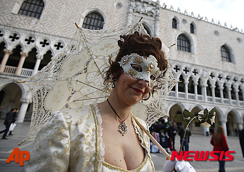 【베네치아=AP/뉴시스】가면을 쓴 여성이 23일(현지시간) 베네치아에서 가면 축체인 베네치아 카니발 개막식에 참여하고 있다. 유럽에 잇따라 발생한 테러와 송년행사 집단성추행 사건에 보안 우려가 커지면서 이탈리아 가면 축제' 베네치아 카니발'이 이날 삼엄한 보안 속에 열렸다. 산마르코 광장에 수천 명이 모인 가운데 베네치아 카니발 개막식이 열렸다. 2016.01.24 