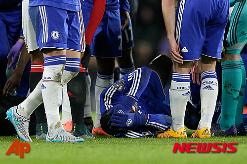 Chelsea's Kurt Zouma reacts in pain as he lies on the field with an injury after landing from a jump during the English Premier League soccer match between Chelsea and Manchester United at Stamford Bridge stadium in London, Sunday, Feb. 7, 2016. (AP Photo/Tim Ireland)