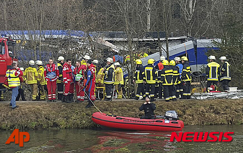 Rescue personell stand in front of two trains that crashed head on near Bad Aibling, southern Germany, Tuesday morning, Feb. 9, 2016. At least four people were killed in the crash. (AP Photo/Sebastian Stepniewski)