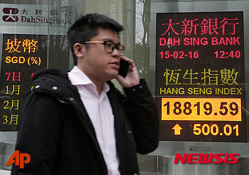 【 홍콩=AP/뉴시스】홍콩에서 15일 한 남성이 은행의 증시 시황 전광판 앞을 지나고 있다. 이날 홍콩 증시는 중국 정부의 추가 부양책에 대한 기대감으로 대폭 상승했다. 2016.02. 15  