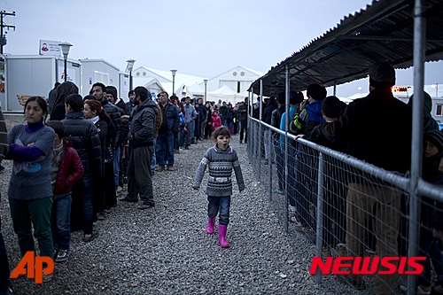 【이도메니=AP/뉴시스】그리스 북부의 마케도니아 접경 도시에서 24일 이주자와 난민들이 비정부기구가 배급하는 식품을 얻기 위해 길게 줄을 서 기다리고 있다. 마케도니아가 입국 심사를 강화해 대기자 적체가 심해졌다. 2016. 2. 24.   