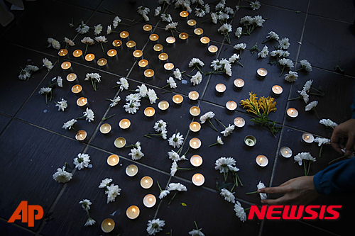 【쿠알라룸푸르=AP/뉴시스】말레이시아항공 여객기 MH370편이 실종된지 2년이 되는 8일, 쿠알라룸푸르 교회에서 신도들이 촛불로 MH370이란 글자를 만들어 실종자들을 추모하고 있다. 2016.03.08 