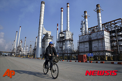 【테헤란=AP/뉴시스】이란 석유부 장관은 미국 기업의 대이란 석유, 가스 산업에 대한 투자를 환영한다고 13일(현지시간) 말했다. 사진은 지난 2014년 12월22일 테헤란의 정유공장에서 한 근로자가 자전거를 타고 공장 옆을 지나가는 모습. 2016.03.14  