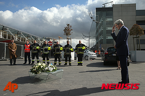 【브뤼셀=AP/뉴시스】존 케리 미국 국무장관이 25일(현지시간) 벨기에 브뤼셀공항에서 테러 희생자들을 위로하기 위한 헌화식을 진행한 뒤 공항 안전요원들을 격려했다. 2016.3.26. 