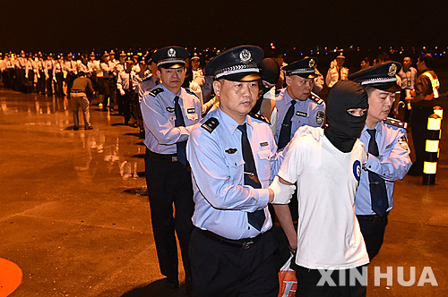 【광저우=신화/뉴시스】 대만인 32명을 포함한 97명의 전화금융사기 용의자들이 30일 중국 광저우 공항에 도착해 수갑을 찬 채 경찰에 끌려가고 있다. 말레이시아 경찰 당국은 이날 대만인 용의자들을 대만이 아닌 중국으로 송환했다. 2016.05.01  