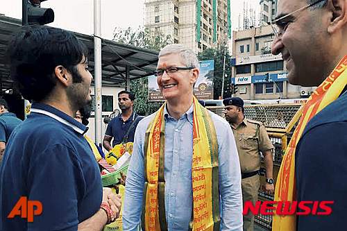 【 뭄바이=AP/뉴시스】애플의 팀 쿡 최고경영자가 18일 인도 뭄바이의 힌두 사원 앞에서 인도인들과 웃으며 대화하고 있다. 오른쪽에 선 사람은 애플 인도 책임자 산자이 카울이다. 2016.05.19  