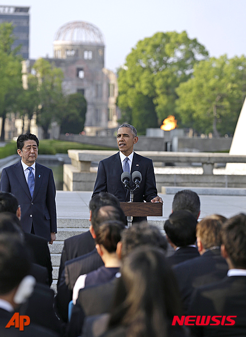 【히로시마=AP/뉴시스】버락 오바마 미국 대통령이 27일 일본 히로시마 평화기념공원에서 위령탑에 헌화한 후 아베 신조 총리와 원폭 생존자 및 관계자들이 지켜보는 가운데 연설하고 있다. 2016.05.27 