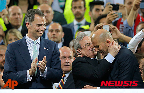 Real Madrid's headcoach Zinedine Zidane, right, is embraced by Real president Florentino Perez as Spain's King Felipe looks on during the Champions League final soccer match between Real Madrid and Atletico Madrid at the San Siro stadium in Milan, Italy, Saturday, May 28, 2016. (AP Photo/Manu Fernandez)