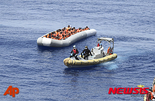 【AP/뉴시스】30일 이탈리아 해군이 공개한 최근의 사진으로, 군인들이 리비아 근해 지중해에서 이주자들을 구조해 이동시키고 있다. 지난 주 사흘 동안 700여 명이 이곳 지중해에서 익사했다. 2016. 5. 30.  
