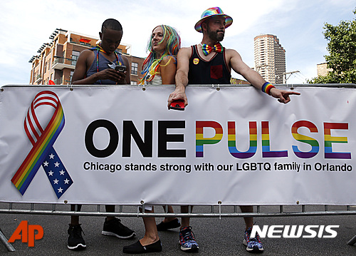 【시카고=AP/뉴시스】성적 소수자 (LGBT)들을 지지하는 시카고 게이축제 참가자들이 테러공포에 지지 않겠다며 올랜도 참사현장인 '펄스 클럽'과의 연대를 주장하는 펼침막을 마련했다. 2016.06.19