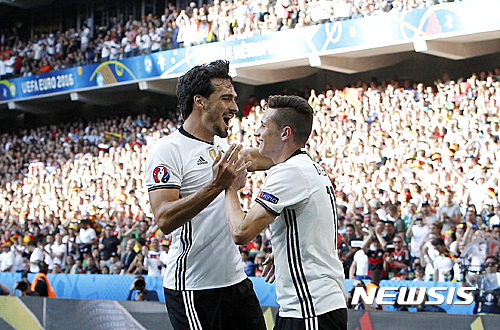 Germany's Julian Draxler, right, celebrates with his teammate Mats Hummels after scoring during the Euro 2016 round of 16 soccer match between Germany and Slovakia, at the Pierre Mauroy stadium in Villeneuve d'Ascq, near Lille, France, Sunday, June 26, 2016. (AP Photo/ Michel Spingler)