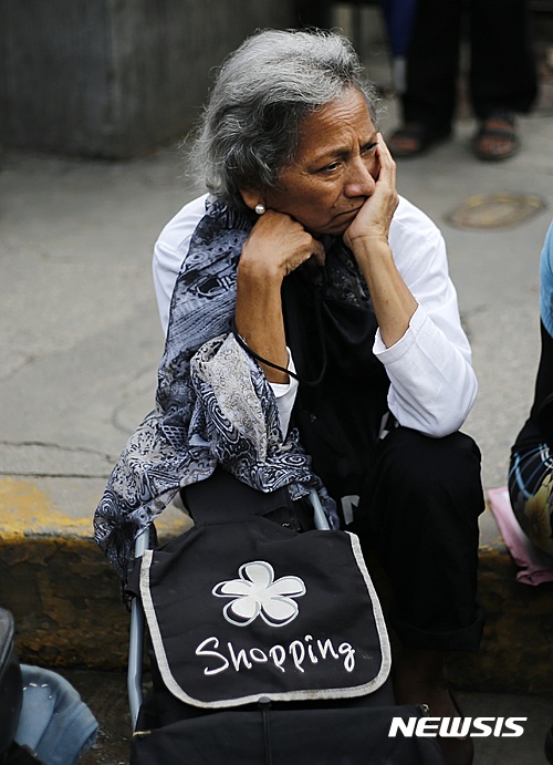 【카라카스=AP/뉴시스】극심한 경제위기를 겪고 있는 베네수엘라 수도 카라카스에서 지난 8일(현지시간) 한 노파가 수퍼마켓 앞에 수심이 가득한 얼굴로 앉아있다. 2016.07.12  