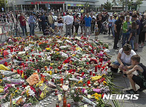 【뮌헨=AP/뉴시스】24일 사람들이 이틀 전 총기 난사로 9명이 숨진 뮌헨의 올림피아 쇼핑 센터 앞에서 희생자들을 추모하고 있다. 2016. 7. 24.  