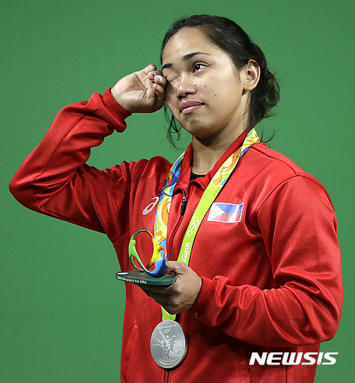 Hidilyn Diaz, of the Philipines, wipes away tears after winning the silver medal in the women's 53kg weightlifting competition at the 2016 Summer Olympics in Rio de Janeiro, Brazil, Sunday, Aug. 7, 2016. (AP Photo/Mike Groll)