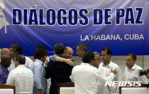 【아바나=AP/뉴시스】24일(현지시간) 쿠바 수도 아바나에서 콜롬비아 평화협상이 타결된 가운데 콜롬비아 정부와 반군 협상 대표 및 옵저버들이 인사하고 있다. 이번 평화협상 타결로 52년간 지속된 콜롬비아 내전이 종식될 것으로 보인다. 2016.08.25 