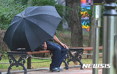 【대구=뉴시스】김동민 기자 = 비가 내리는 26일 오후 대구시 중구 한 벤치에 쉬고 있는 시민이 우산을 고정시킨 채 비를 피하고 있다. 2016.08.26. life@newsis.com