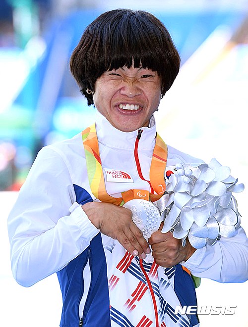 【리우데자네이루(브라질)=뉴시스】사진공동취재단 = 13일(한국시간) 오후 브라질 리우데자네이루 올림픽 스테디움에서 벌어진 육상 여자 200m결선에서 한국의 전민재가 은메달을 차지했다.전민재가 시상식에서 은메달을 걸고 기뻐하고 있다.전민재의 장애유형은 뇌병병장애로 6살 때 열병을 앓아 장애를 겪게 되었다. 우리나라 나이로 40세로 나이가 많은 편이지만 꾸준한 체력관리와 남다른 근성으로 이번 패럴림픽을 준비했다.2012년 런던 패럴림픽때 처음 출전했던 전민재는 런던대회에서 100m와 200m에서 각각 은메달을 따며 주목을 받게 됐다. 2016.09.14. photo@newsis.com