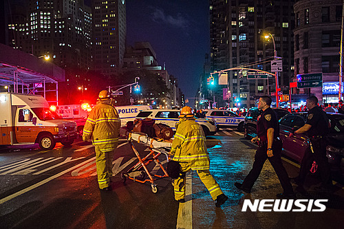 【 뉴욕=AP/뉴시스】미국 뉴욕 맨해튼 첼시 지역에서 17일(현지시간) 폭발 사건이 일어난 직후 소방대원들이 부상자를 옮기고 있다. 2016.09.18 
