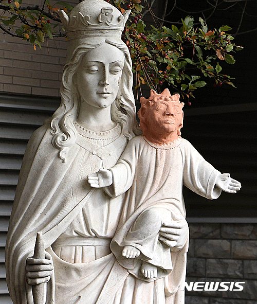【서드버리=AP/뉴시스】캐나다 온타이로주 서드버리에 있는 생텐데펭 성당의 성모마리아와 아기 예수 석상. 지역의 조각가가 훼손된 아기 예수상의 머리 부분을 돌이 아닌 테라코타로 제작한 데다가, 기존의 아기 예수 이미지와는 판이하게 다른 모습이어서 논란이 되고 있다. 2016.10.21  