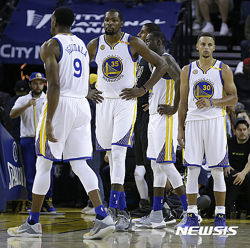 Golden State Warriors, from left, Andre Iguodala (9), Kevin Durant (35) and Stephen Curry (30) wait during a called foul during the second half of an NBA basketball game against the San Antonio Spurs on Tuesday, Oct. 25, 2016, in Oakland, Calif. (AP Photo/Ben Margot)