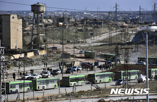 【알레포=사나통신·AP/뉴시스】시리아 정부군이 탈환한 알레포 동부지역에서 15일(현지시간) 시 밖으로 빠져나가려는 주민들을 태울 버스들이 줄지어 대기하고 있다. 녹색 버스는 정부가 제공한 것이다. 사진은 시리아 국영 사나통신이 제공한 것이다. 2106.12.16 